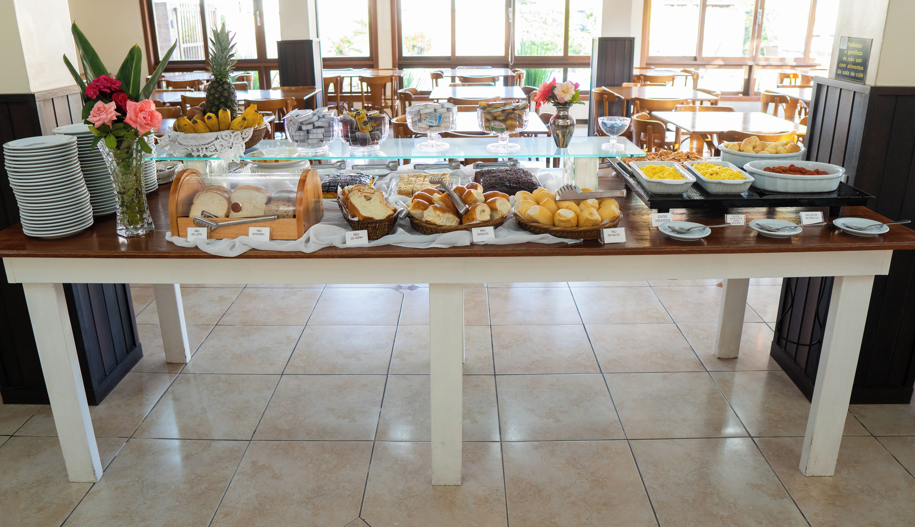 Una mesa de buffet con diversas opciones de comida y un jarrón de flores.