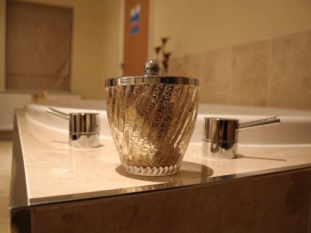 A bathroom with a glass bowl on the counter, a faucet, and a mirror.