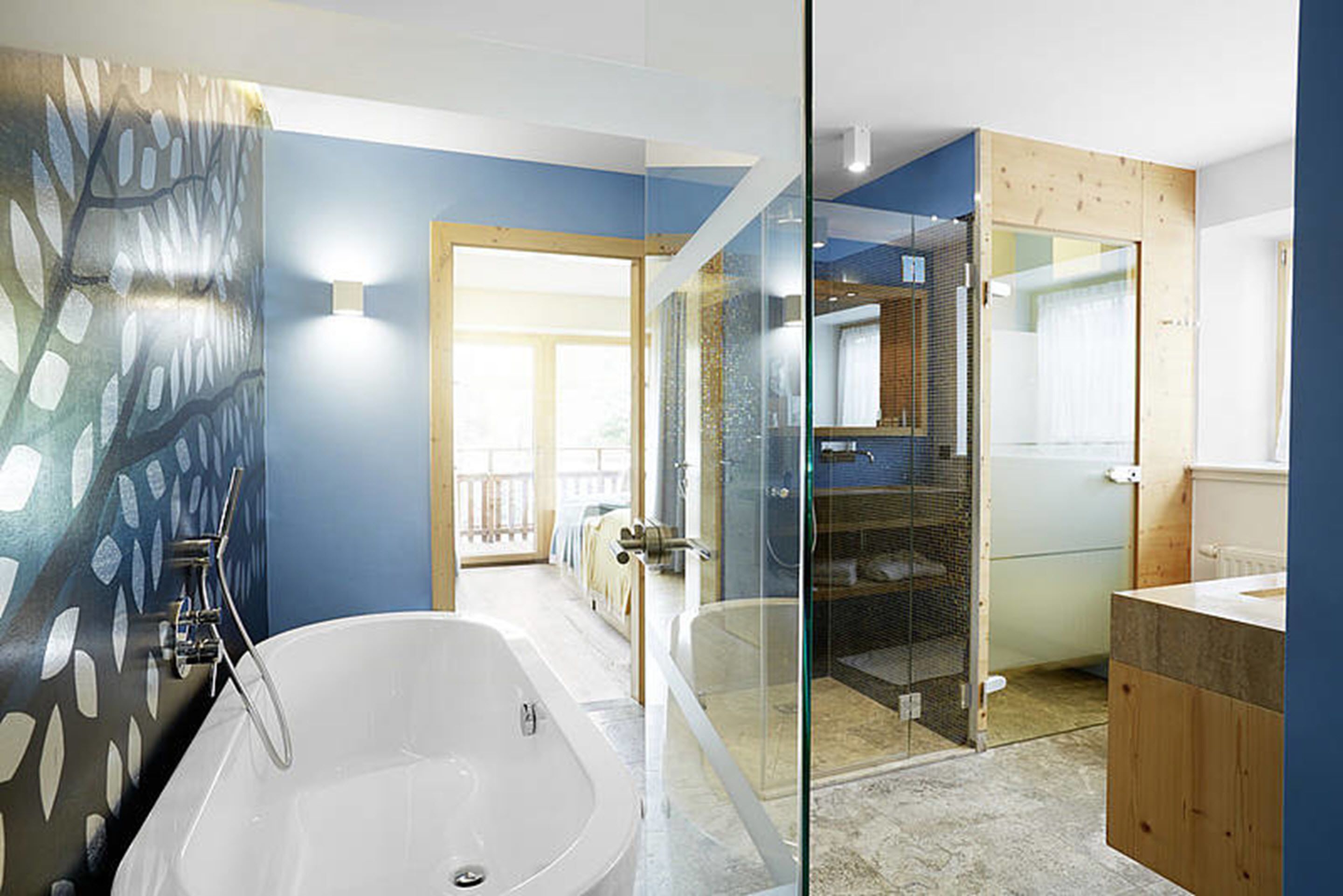 Un baño moderno con una bañera grande, cabina de ducha de vidrio y un mueble de tocador de madera.