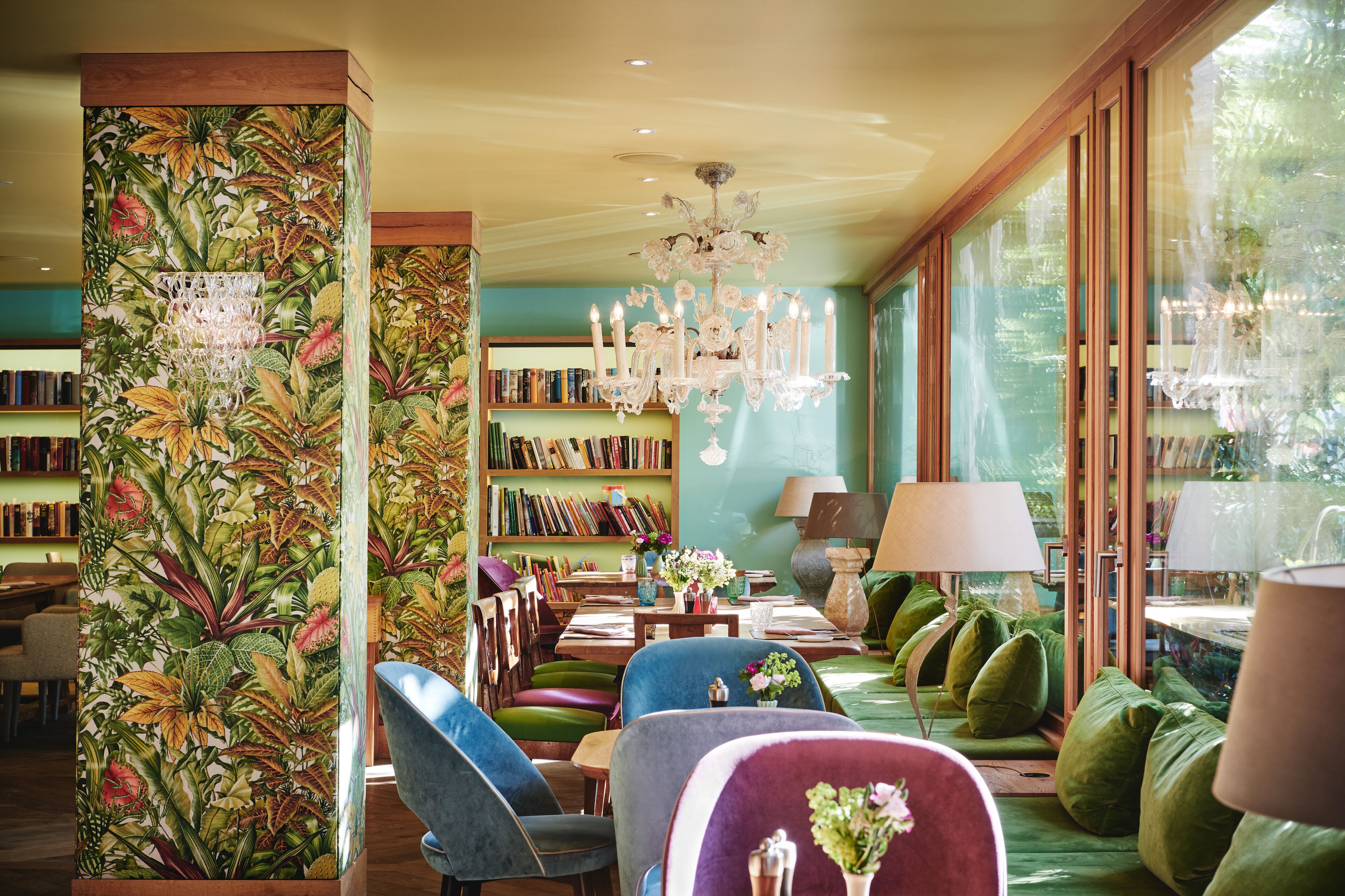 A library with bookshelves, a chandelier, and comfortable seating areas.