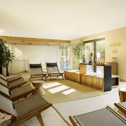 A modern interior with a seating area, wooden furniture, and large windows.