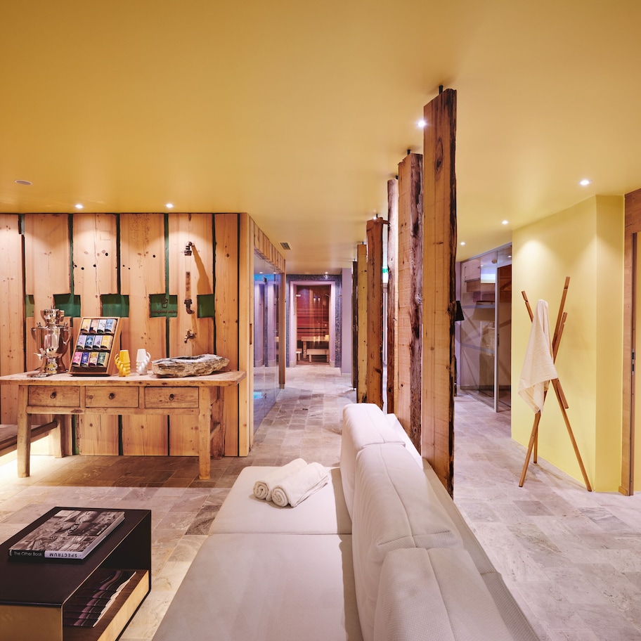 A modern interior with wooden paneling, a reception desk, a sofa, and a bench.