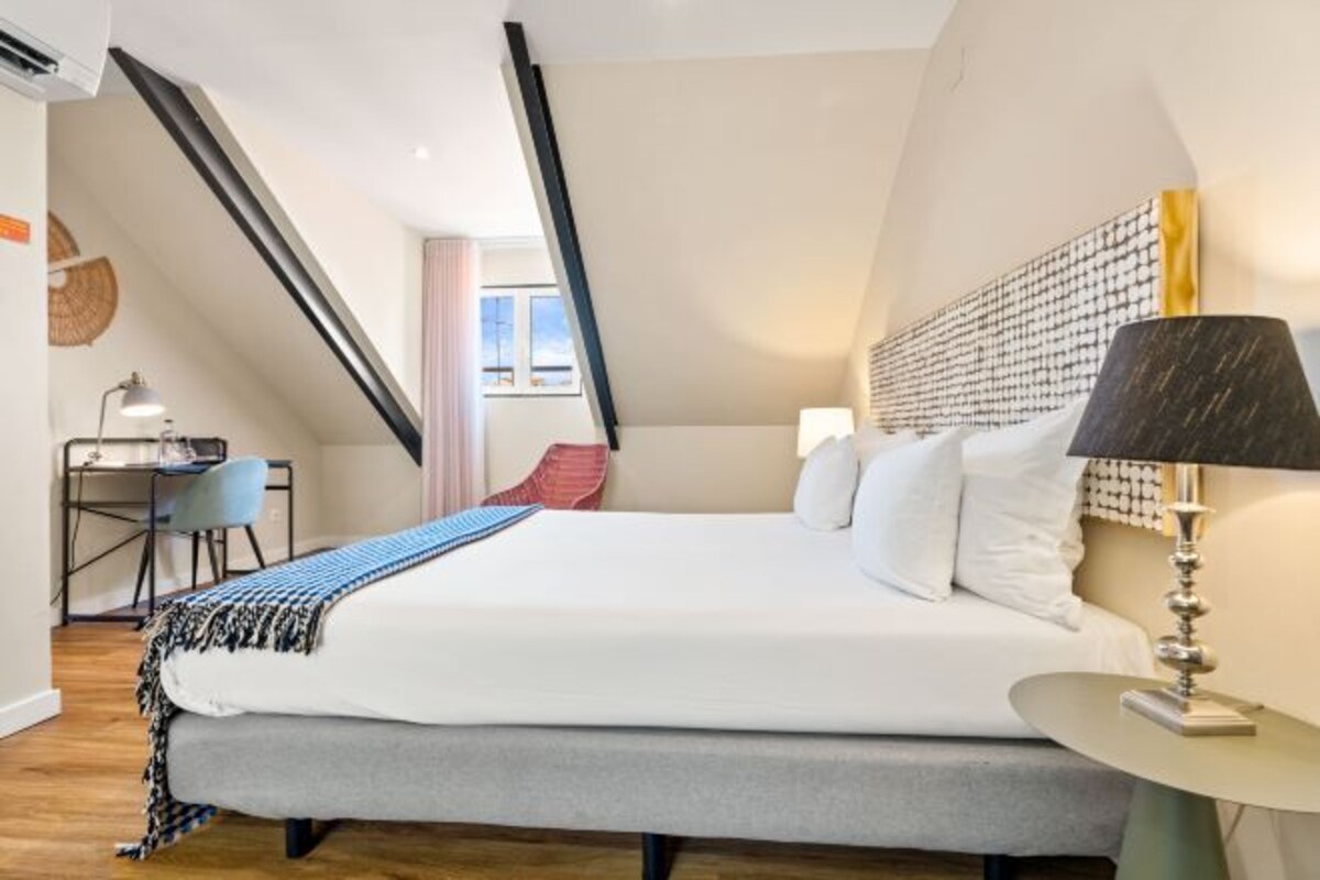 Una camera da letto moderna con un letto grande, una scrivania e una sedia.