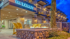 A hotel with a stone facade, a fire feature, and a sign reading "THE LOBBY".