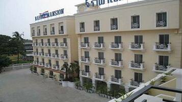 Un hotel de diversos pisos amb balcons i un rètol en una llengua estrangera.