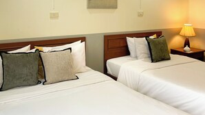 A hotel room with two beds, a nightstand with a lamp, a painting on the wall, and a ceiling light. - Rafael Mansion Bangkok Airport (Bang Phli)