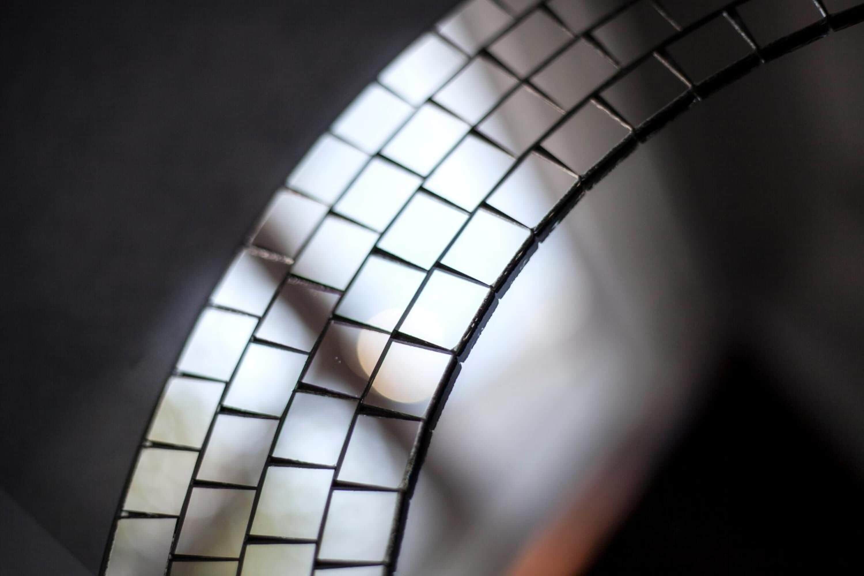 A close-up of a curved metallic structure with a grid pattern.