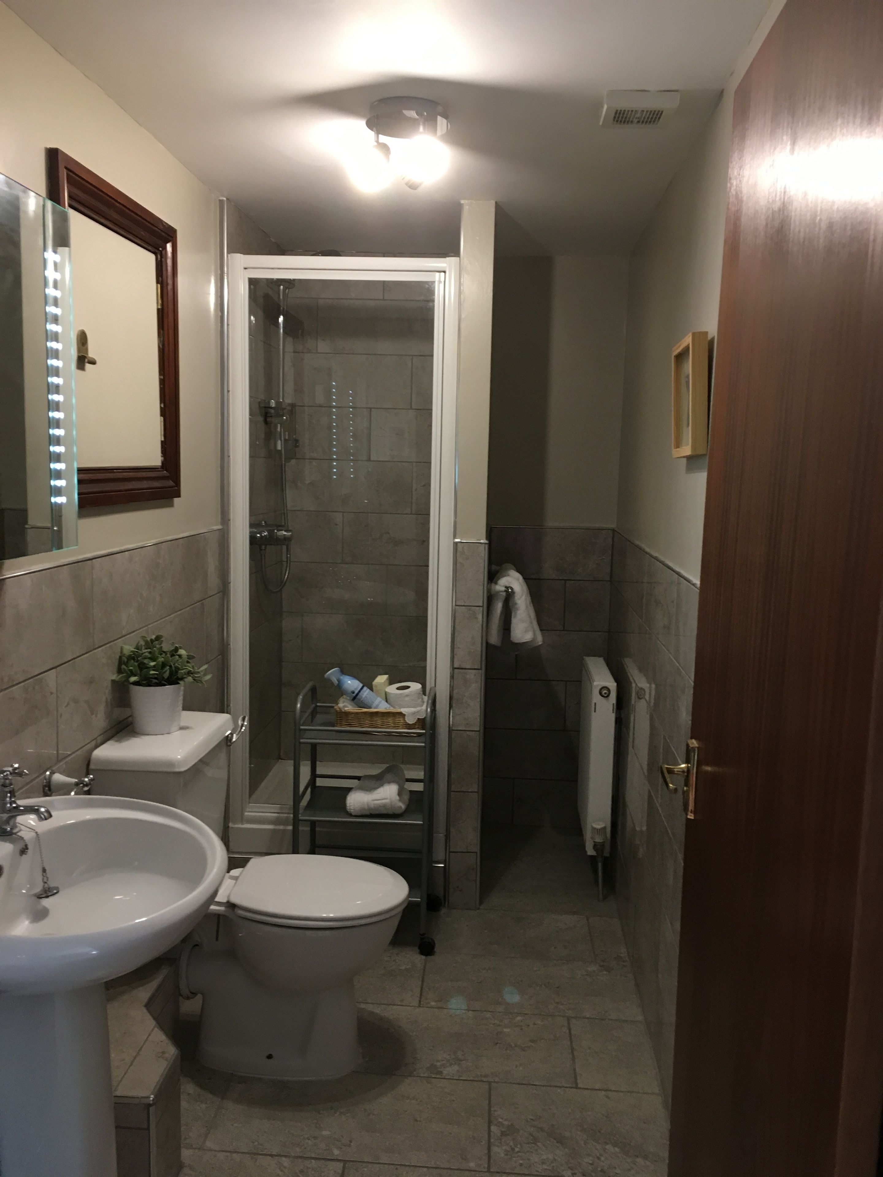 Un baño pequeño con inodoro, lavamanos y ducha.