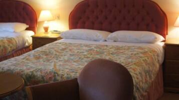A hotel room with a large bed, a chair, and a bedside table.