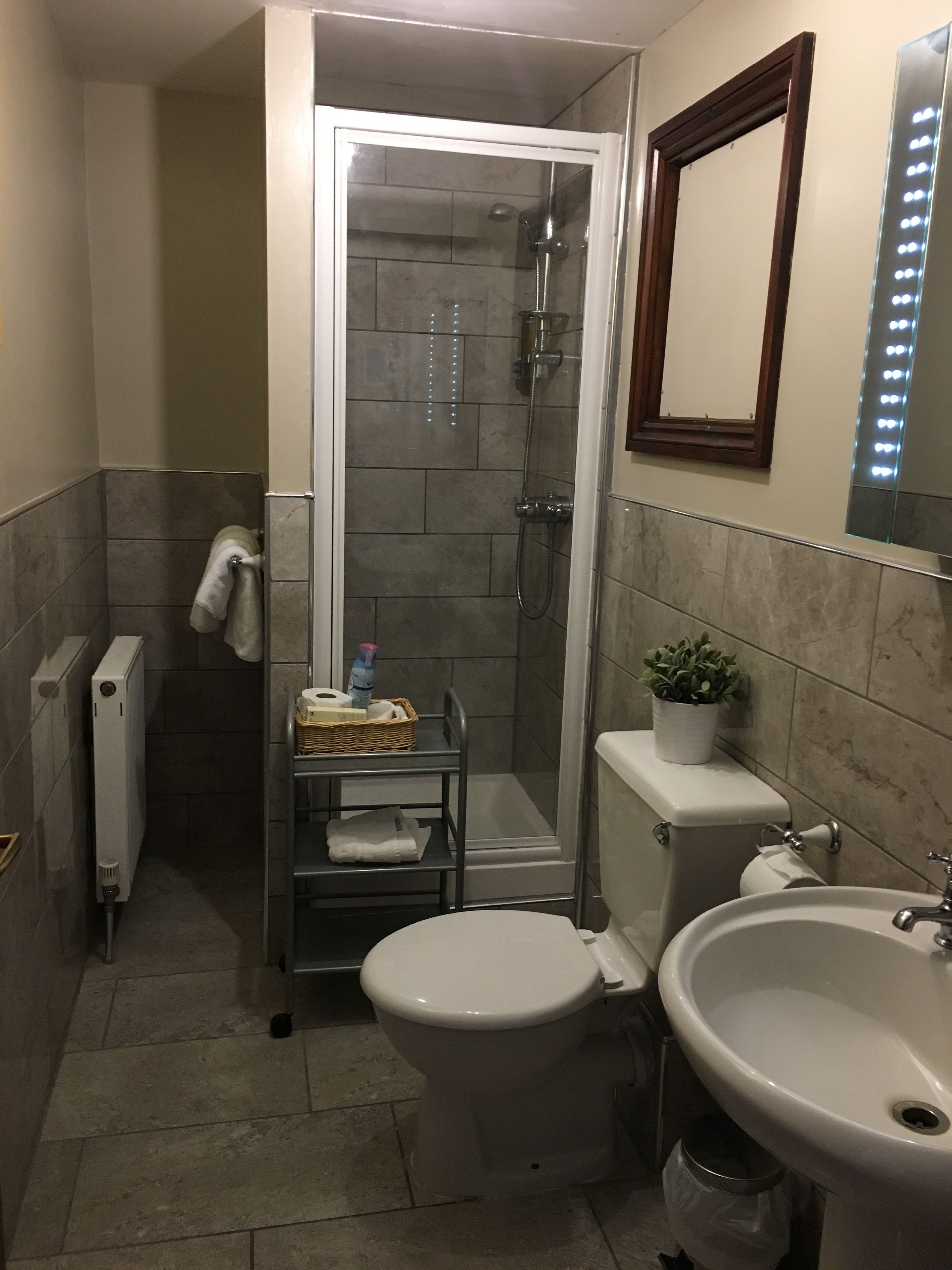 A compact bathroom with a shower, toilet, and sink.