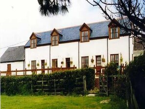 A row of white houses with brown roofs and multiple windows. - Mullacott Farm (Ilfracombe)