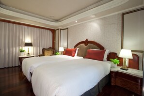 A hotel room with two beds, a large mirror, and a nightstand with a lamp. - Happiness Hotel (Taipei)