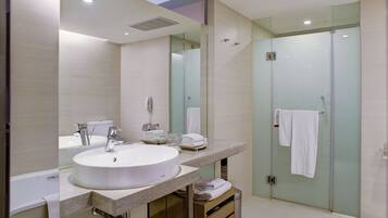 A modern bathroom with a large sink, mirror, and glass shower enclosure.