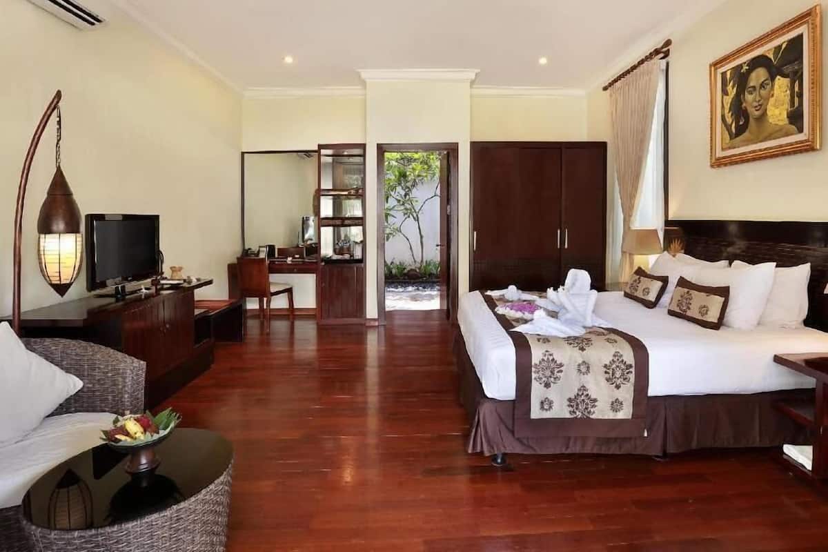 A hotel room with a bed, desk, chair, and a television.