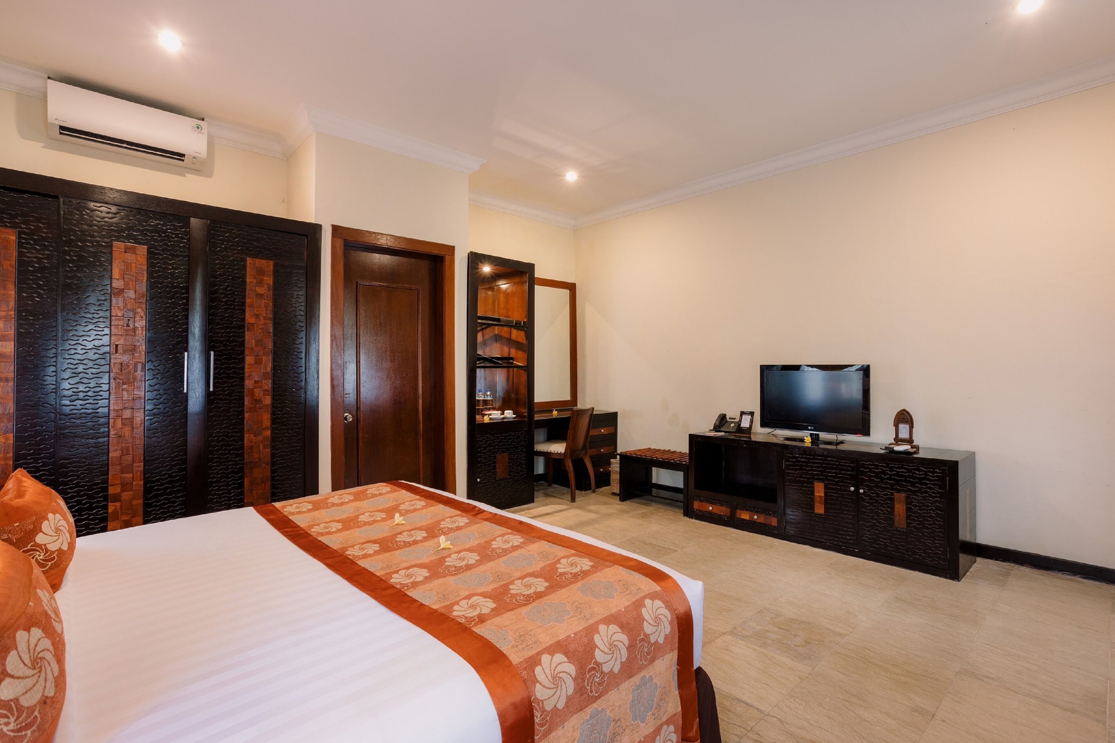 Une chambre d’hôtel équipée d’un lit, d’une télévision, d’un bureau et d’une armoire.
