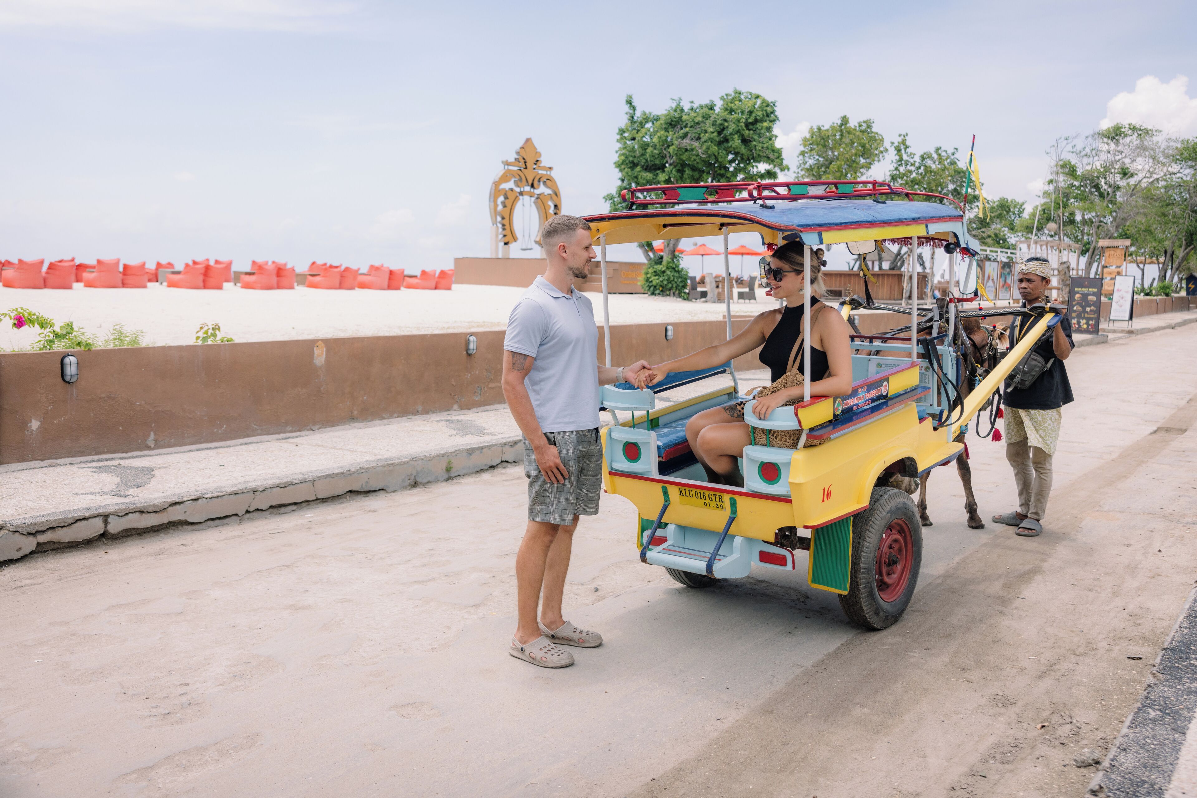 Un tuk-tuk avec un passager et un chauffeur sur un pont.