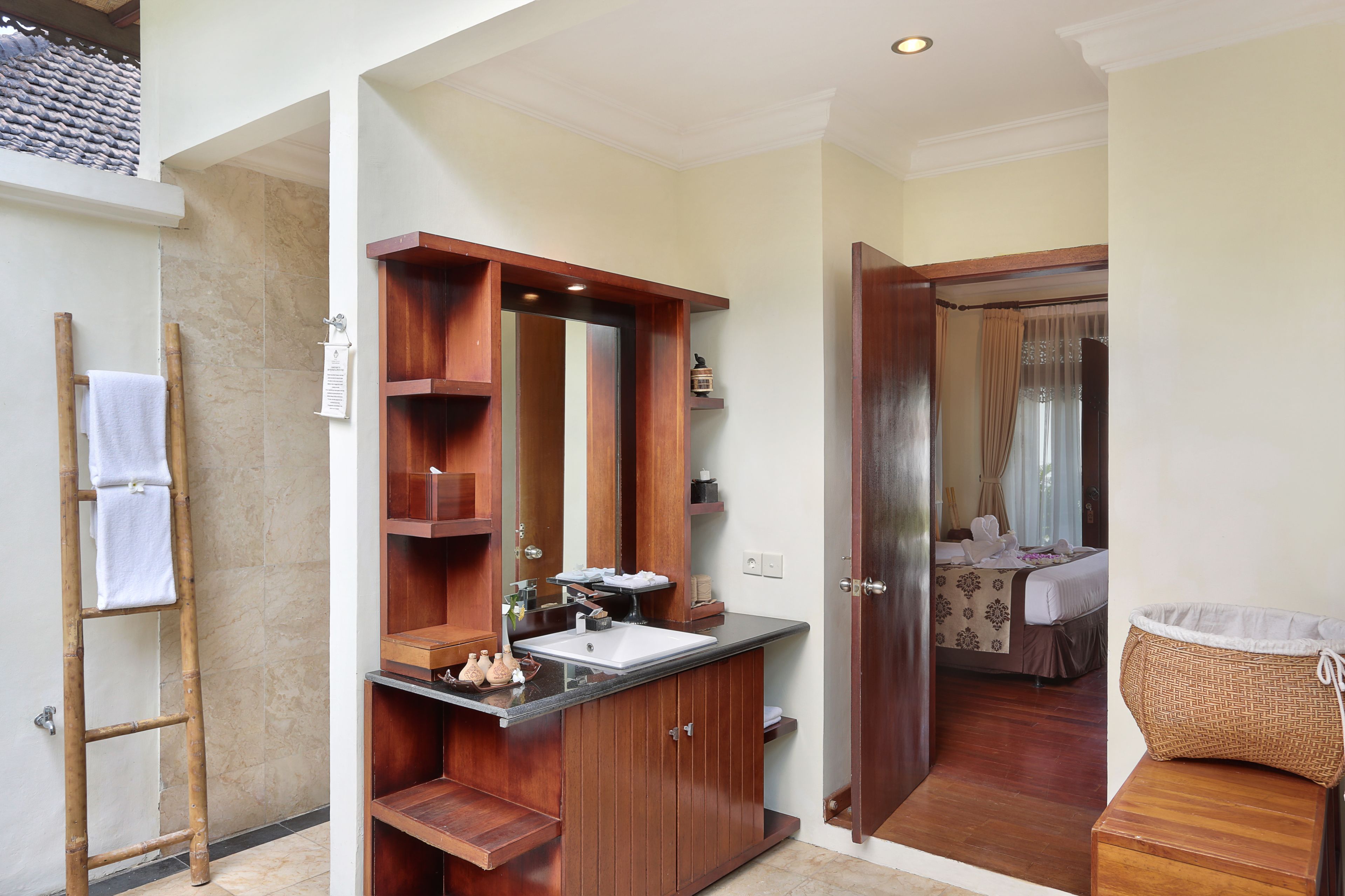 A bathroom with a wooden vanity, a large mirror, and a shower area.