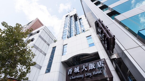Een modern gebouw met een bord voor Charming City Hotel.