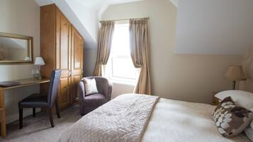 Quarto com cama, escrivaninha, cadeira e guarda-roupa.