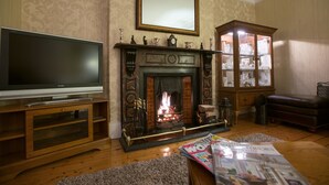 A living room with a fireplace, a television, and a magazine on the coffee table.
