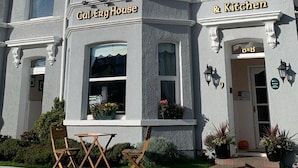 A two-story building with a sign reading "Cal-ERG House & Kitchen."