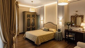 A hotel room with a bed, a desk, a chair, a dresser, and a large mirror. - Ca' Dei Polo (Venice)