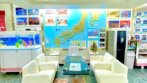 A lobby with a map, seating, a fish tank, and a refrigerator. - Hotel Hoshi Kai Kan (Tokyo)