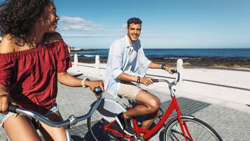 Ride along the oceanfront path, bordered by a white railing, with the sea stretching out before you.