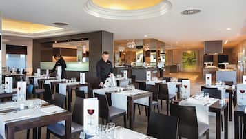 Een restaurant met gedekte tafels, een bar en een toonbank met een menu.