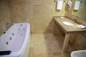 Un baño con bañera, lavabo y espejo.