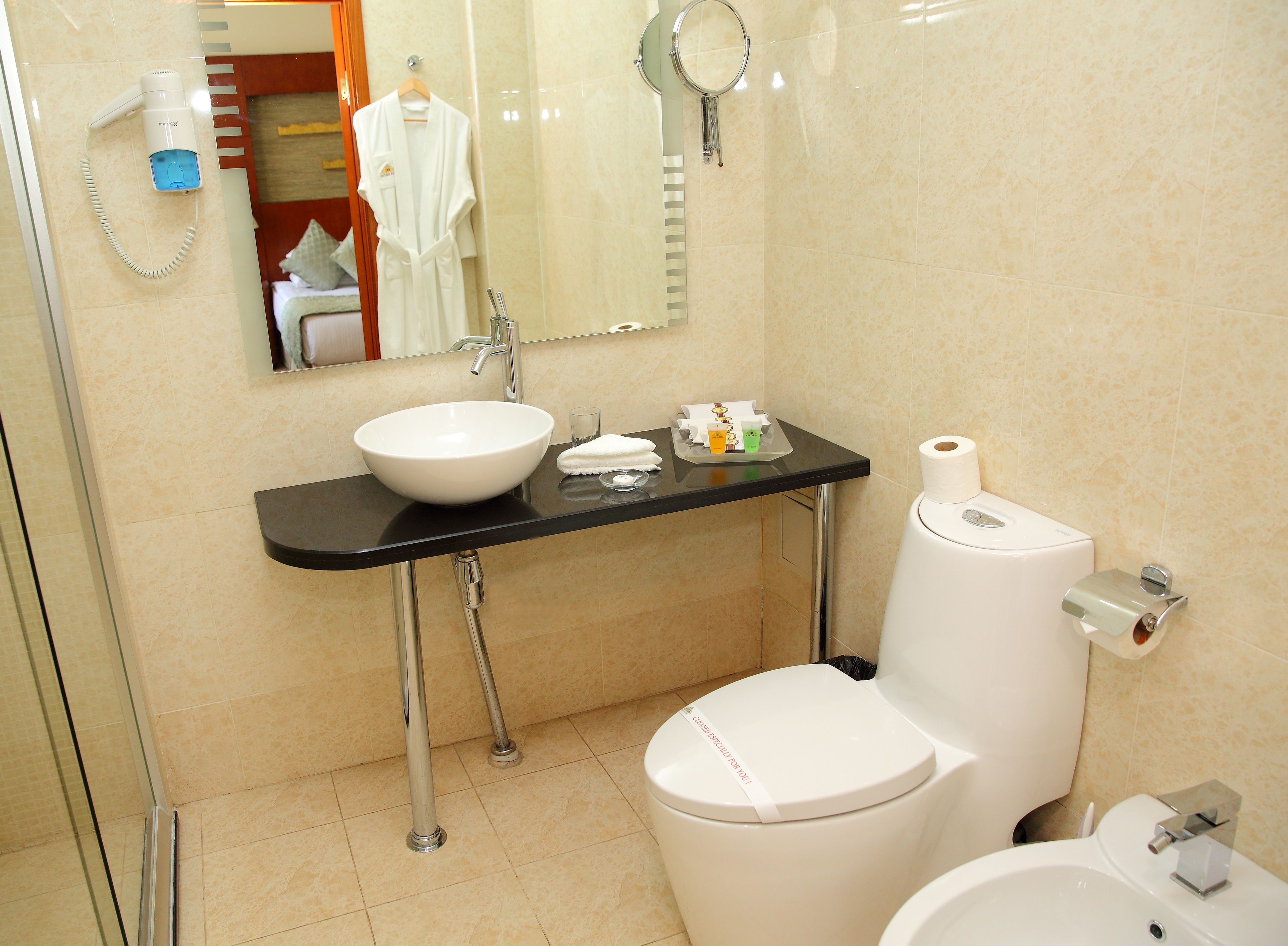 A modern bathroom with a white sink, a toilet, and a bidet.
