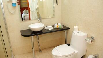 A modern bathroom with a white sink, a toilet, and a bidet.