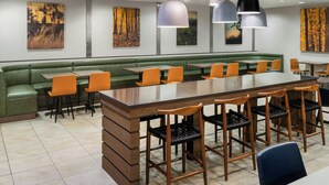 A restaurant with a long counter, green cushioned seating, and multiple pendant lights. - Fairfield Inn & Suites by Marriott Denver Aurora / Parker (Aurora)