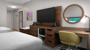 A hotel room with a bed, a desk with a chair, a flat-screen TV, a microwave, and a mirror.