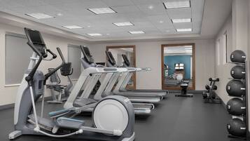 A gym with treadmills, elliptical machines, and weightlifting equipment.