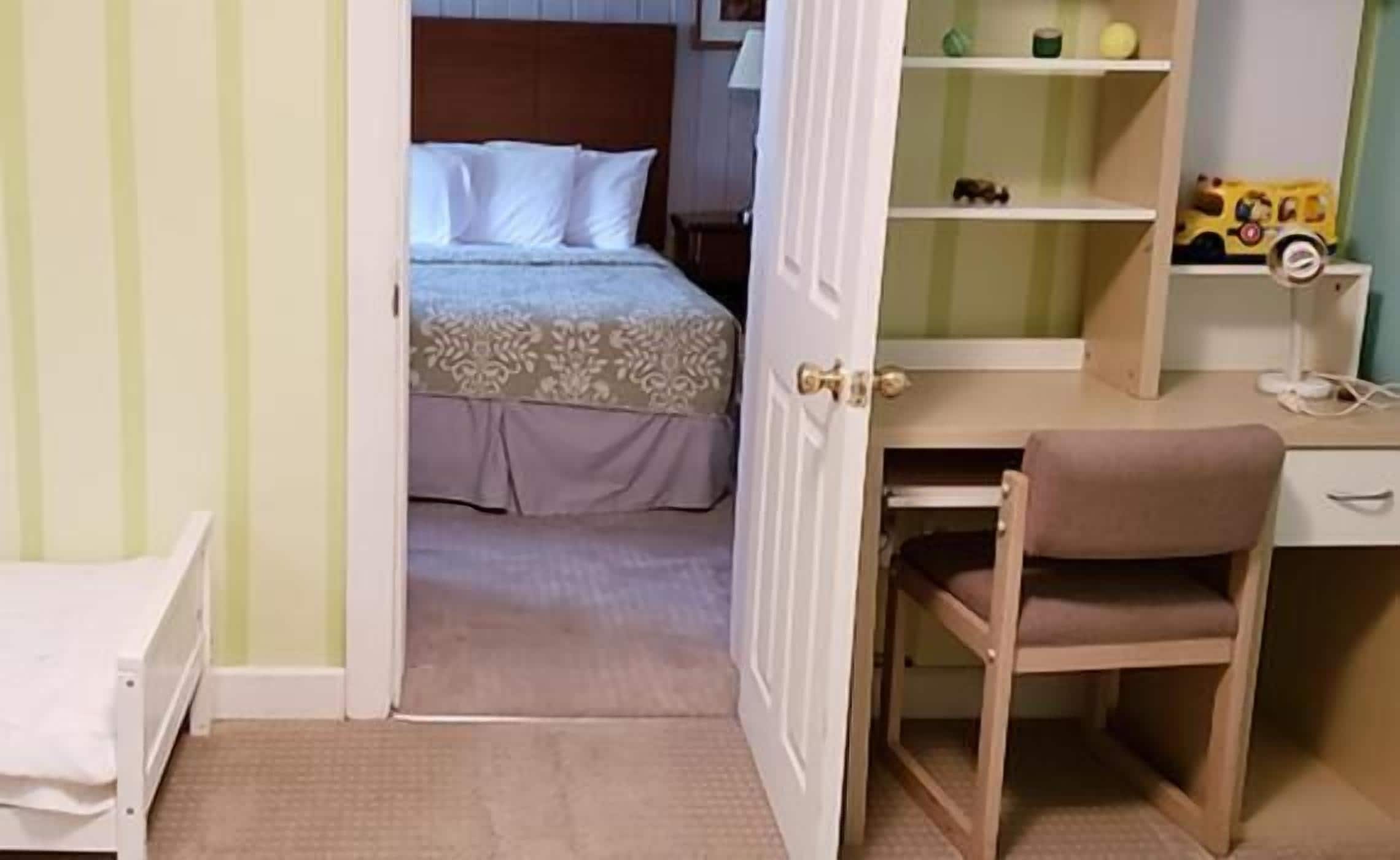 Ein Schlafzimmer mit einem Bett, einem Schreibtisch und einem Stuhl.