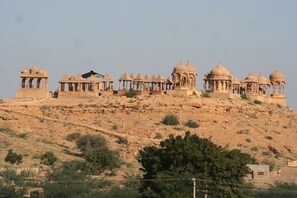 A historical building with multiple domes and pavilion structures on a hillside.