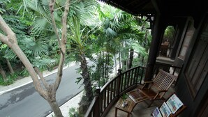 A wooden balcony with a view of a street and lush greenery. - Sokhalay Angkor Villa Resort (Siem Reap)