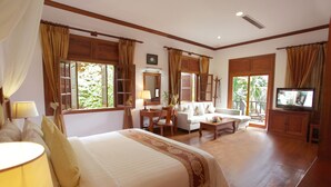 A spacious hotel room with a large bed, a sofa, a TV, and a dining area. - Sokhalay Angkor Villa Resort (Siem Reap)