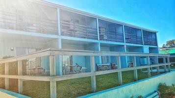 Un edificio de varios pisos con un balcón en el nivel superior.