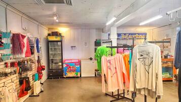 A clothing store with racks of clothes, a vending machine, and a sign for 'Marina'.