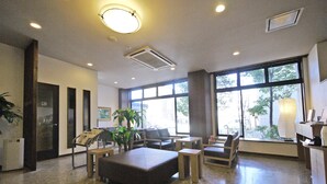 A spacious lobby with a reception desk, seating area, and large windows providing natural light. - Hotel Route Inn Shimada Ekimae (Shimada)