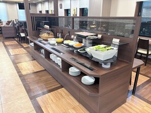 Una barra de buffet con diversos alimentos y utensilios.