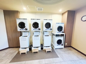 Cuatro secadoras automáticas en un entorno comercial.