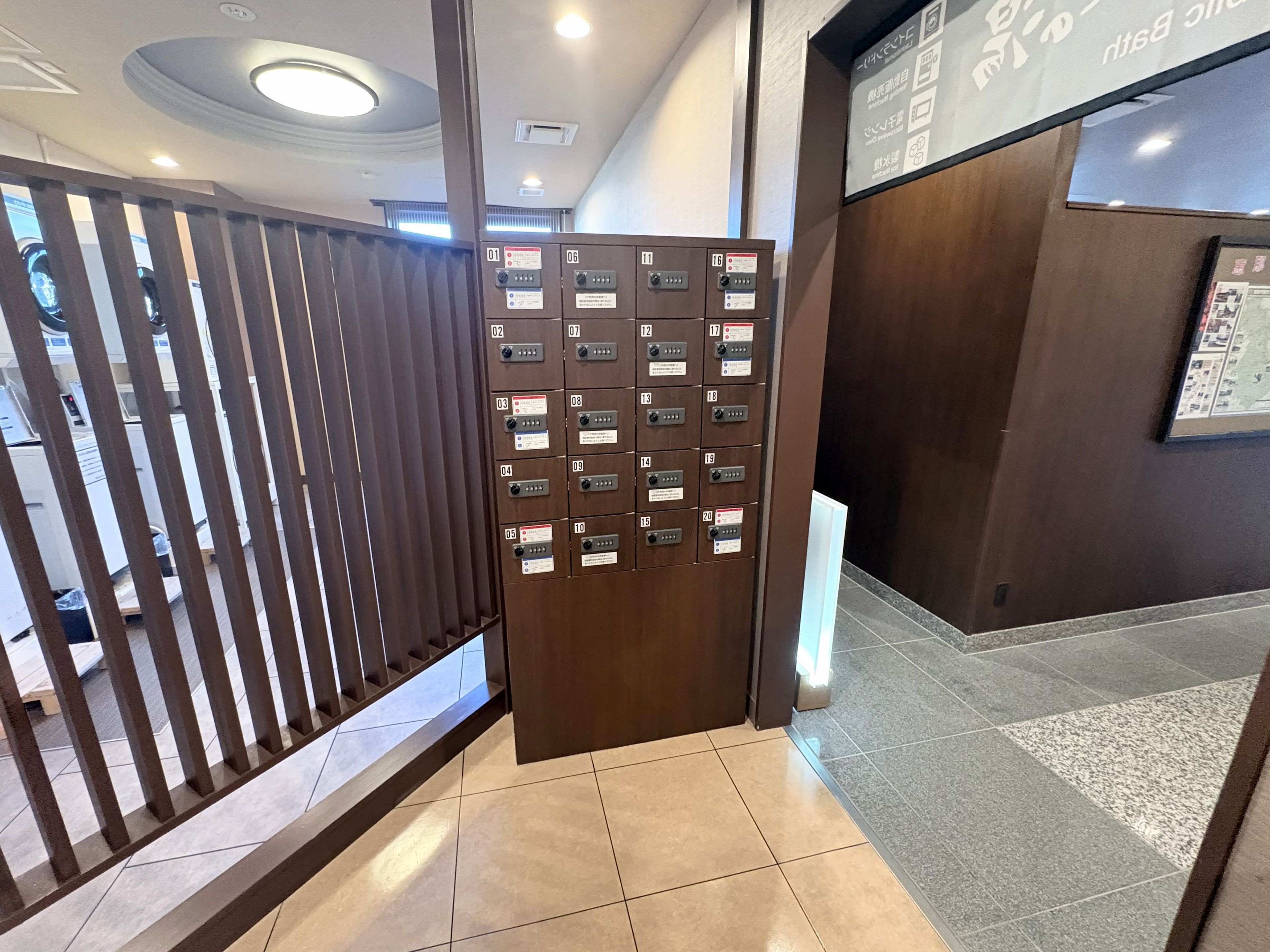 Zona de recepción de un hotel con un separador de madera y varios casilleros numerados.