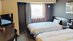 A hotel room with two beds, a desk with a television, and a window with curtains. - Hotel Route Inn Gifu Hashima Ekimae (Hashima)