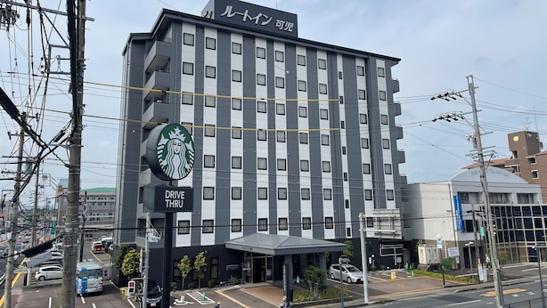 A multi-story hotel with a Starbucks drive-thru and a parking lot. - Hotel Route Inn Kani (Kani)