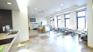 A spacious lobby with a reception desk, seating area, and large windows allowing natural light. - Hotel Route Inn Kani (Kani)