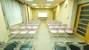 A conference room with rows of chairs, a whiteboard, and a door with a frosted glass panel. - Hotel Route Inn Minokamo (Minokamo)
