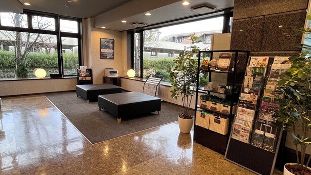 A modern lobby with a wet floor, large windows, and a reception desk with informational brochures. - Hotel Route Inn Minokamo (Minokamo)